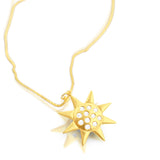 14K gold sun necklace featuring radiant diamond-set pendant photographed at an angle
