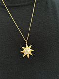 14K gold sun necklace styled on black top