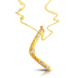 Close-up of diamond set in gold boomerang pendant
