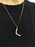 Woman wearing 14K gold boomerang necklace